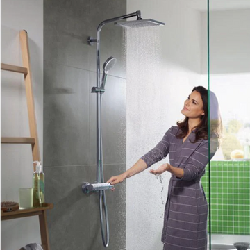 A woman testing a modern shower in a sensory-friendly bathroom.