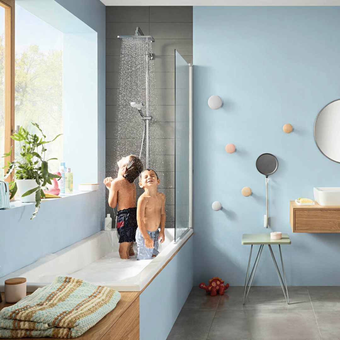 Children enjoying a rain shower head in a modern bathroom.