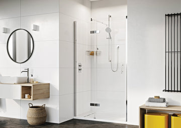 Modern bathroom with glass shower, round mirror, and minimalist decor.