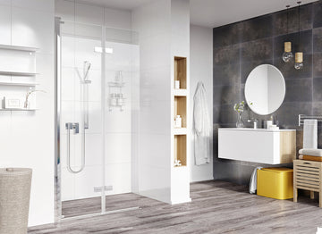 Modern bathroom with glass shower, round mirror, and wood accents.